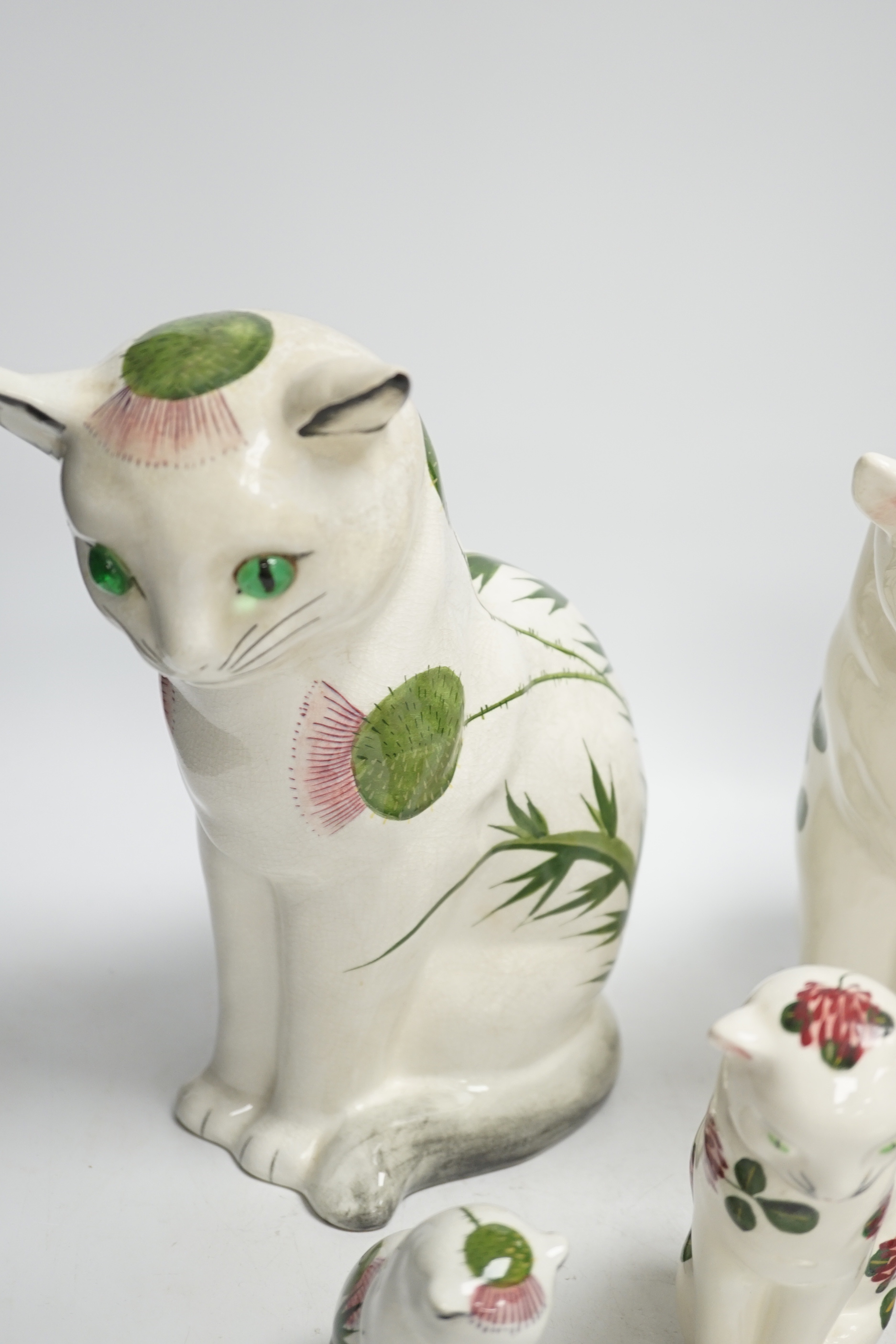 A Plichta clover pattern cat, a Plichta thistle pattern cat, together with two small Plichta cats and a seal, largest 26cm high